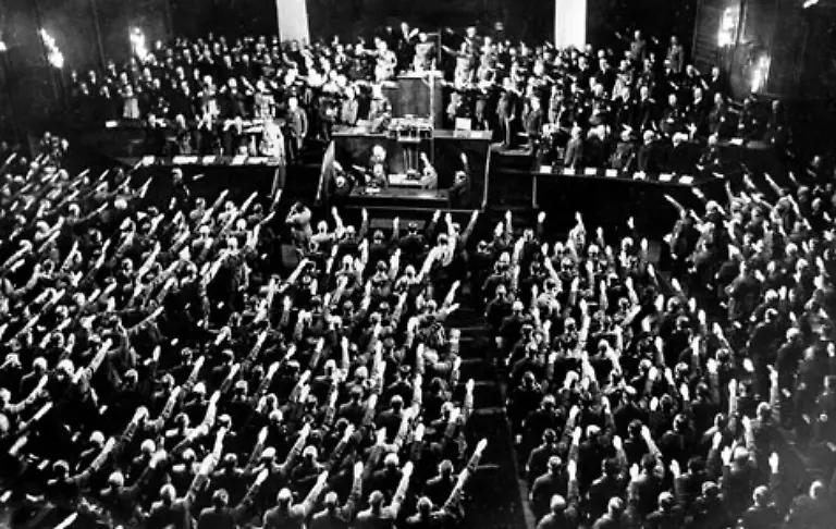 Nach-einem-Jahr-sitzt-Hitler-fest-im-Sattel-Die-Nationalsozialisten-haben-alle-wichtigen-Positionen-im-Reich-erobert-Nur-noch-wenig-trennt-Hitler-von-der-absoluten-Macht-Der-Reichstag-der-nur-noch-pro-forma-zusammentritt-jubelt-Hitler-am-30-Januar-1934-zu