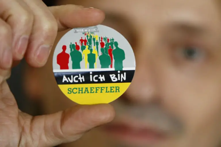 Sondermaschinenbau-beschaeftigter-aelterer-Arbeiter-bringt-seine-Zukunftssorge-mit-einem-Satz-auf-den-Punkt-Es-geht-um-unser-Leben-Die-von-jungen-Frauen-in-der-Altstadt-verteilte-Plakette-Auch-wir-sind-Schaeffler-prangt-auch-am-Revers-von-einem-Spediteur