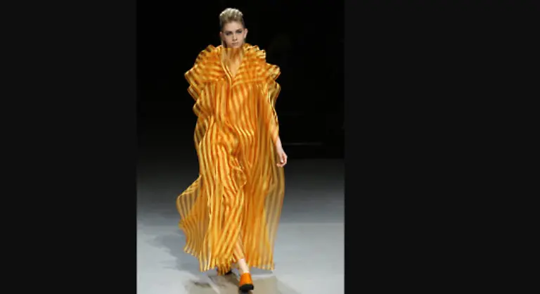 und-lange-Roben-aus-kunstvoll-uebereinandergelegten-Stoffquadraten-Die-Entwuerfe-wirkten-wie-vom-Wind-aufgeblaeht