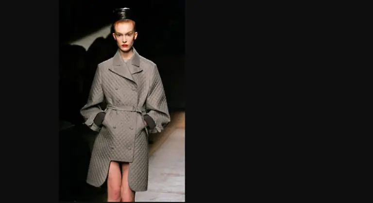 Dann-kamen-schmal-geschnittene-Nadelstreifenmaentel-oder-kostueme-mit-leicht-betonten-Schultern-spitz-zulaufendem-Revers-und-knapp-knielangem-Bleistiftrock-strahlend-weisse-Blusen-mit-weiten-gerafften-Aermeln-oder-sanft-glitzernde-Etuikleider-in-Braungrautoenen