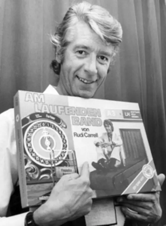 Doch-die-TV-Sendung-des-Jahrzehnts-ist-Am-laufenden-Band-mit-Rudi-Carrell-die-zwischen-1974-und-1979-laeuft-Bis-zu-30-Millionen-Zuschauer-verfolgen-wie-Foehnhauben-und-Toaster-am-Gewinner-vorbeiziehen