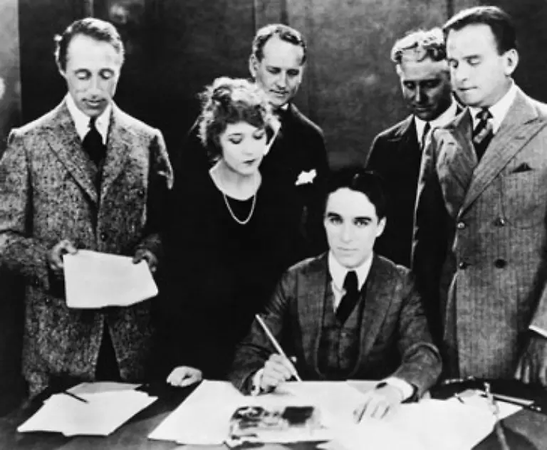 1919-gruendet-er-mit-anderen-Filmschaffenden-die-unabhaengige-United-Artists-Corporation-Im-Bild-sitzend-mit-D-W-Griffith-l-Mary-Pickford-2-v-l-Douglas-Fairbanks-Sr-r