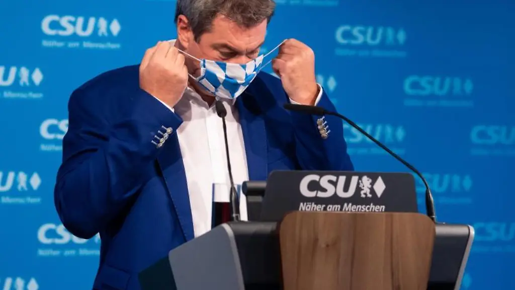 Markus-Soeder-CSU-zieht-sich-einen-Mund-Nasen-Schutz-auf