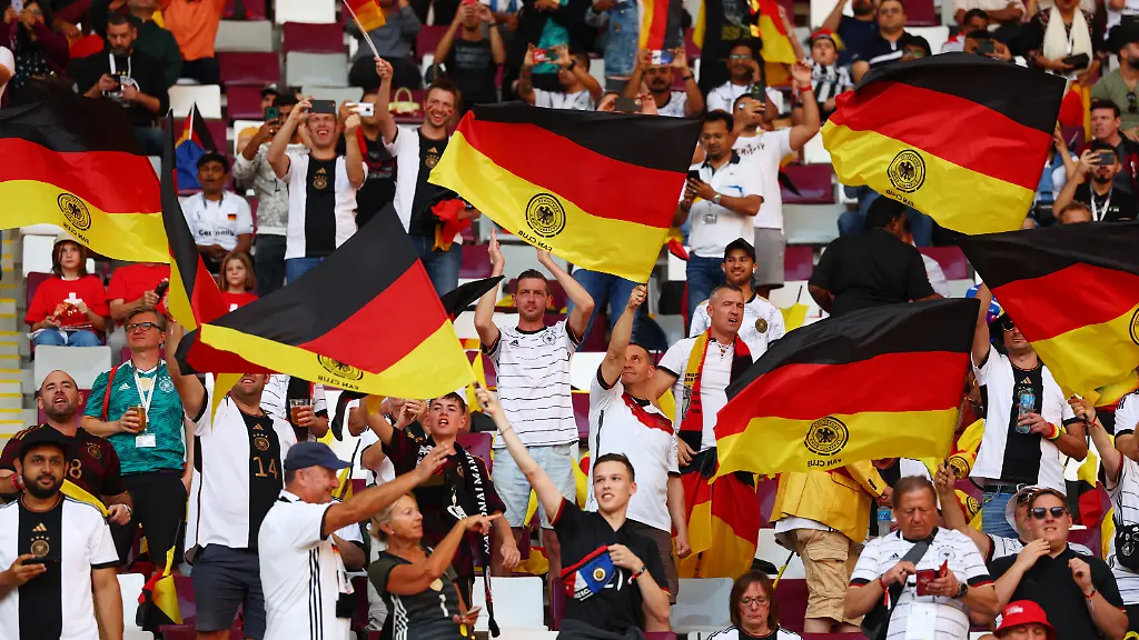 Fussball-WM-Deutschland-Japan-Vorrunde-Gruppe-E-Spieltag-1-Chalifa-International-Stadium-Deutsche-Fans-schwenken-vor-dem-Spiel-schwarz-rot-goldene-Fahnen
