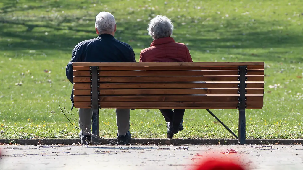 Aelteres-Paar-sitzend-auf-einer-Parkbank-im-Stadtpari-von-Mainz-in-Rheinland-Pfalz