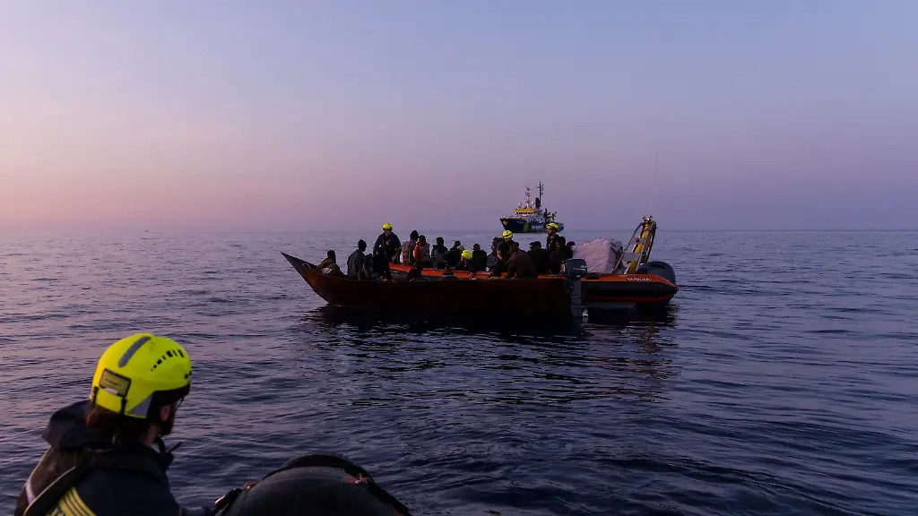 HANDOUT-HANDOUT-Dieses-am-28-05-2024-von-der-Hilfsorganisation-SOS-Humanity-zur-Verfuegung-gestellte-Foto-zeigt-Migranten-auf-einem-Boot-und-Seenotretter-im-Mittelmeer-Seenotretter-haben-im-Mittelmeer-nahe-der-italienischen-Insel-Lampedusa-ein-totes-Baby-geborgen-Es-befand-sich-an-Bord-des-Eisenbootes-auf-dem-mehr-als-40-Menschen-unterwegs-waren-und-das-die-Besatzung-des-Rettungsschiffs-Humanity-1-am-fruehen-Dienstagmorgen-entdeckt-hatte