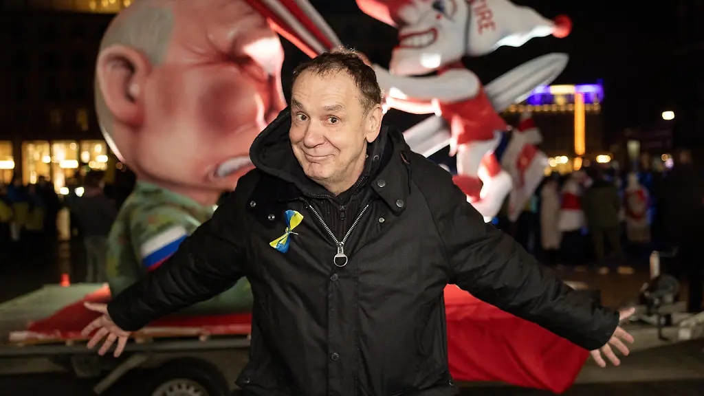 Kuenster-Jacques-Tilly-vor-seinem-Mottwagen-Putin-spiesst-den-Duesseldorfer-Hoppeditz-auf-Kundgebung-auf-dem-Roncalliplatz-in-Koeln-anlaesslich-des-Jahrestages-des-russischen-Grossangriffs-auf-die-Ukraine-Veranstalter-rufen-zur-Solidaritaet-mit-der-Ukraine-sowie-zur-Unterstuetzung-von-Frieden-Souveraenitaet-und-Menschenrechten-auf-Die-Veranstaltung-richtet-sich-an-Buergerinnen-und-Buerger-die-ein-Zeichen-gegen-den-Krieg-und-fuer-internationale-Solidaritaet-setzen-wollen