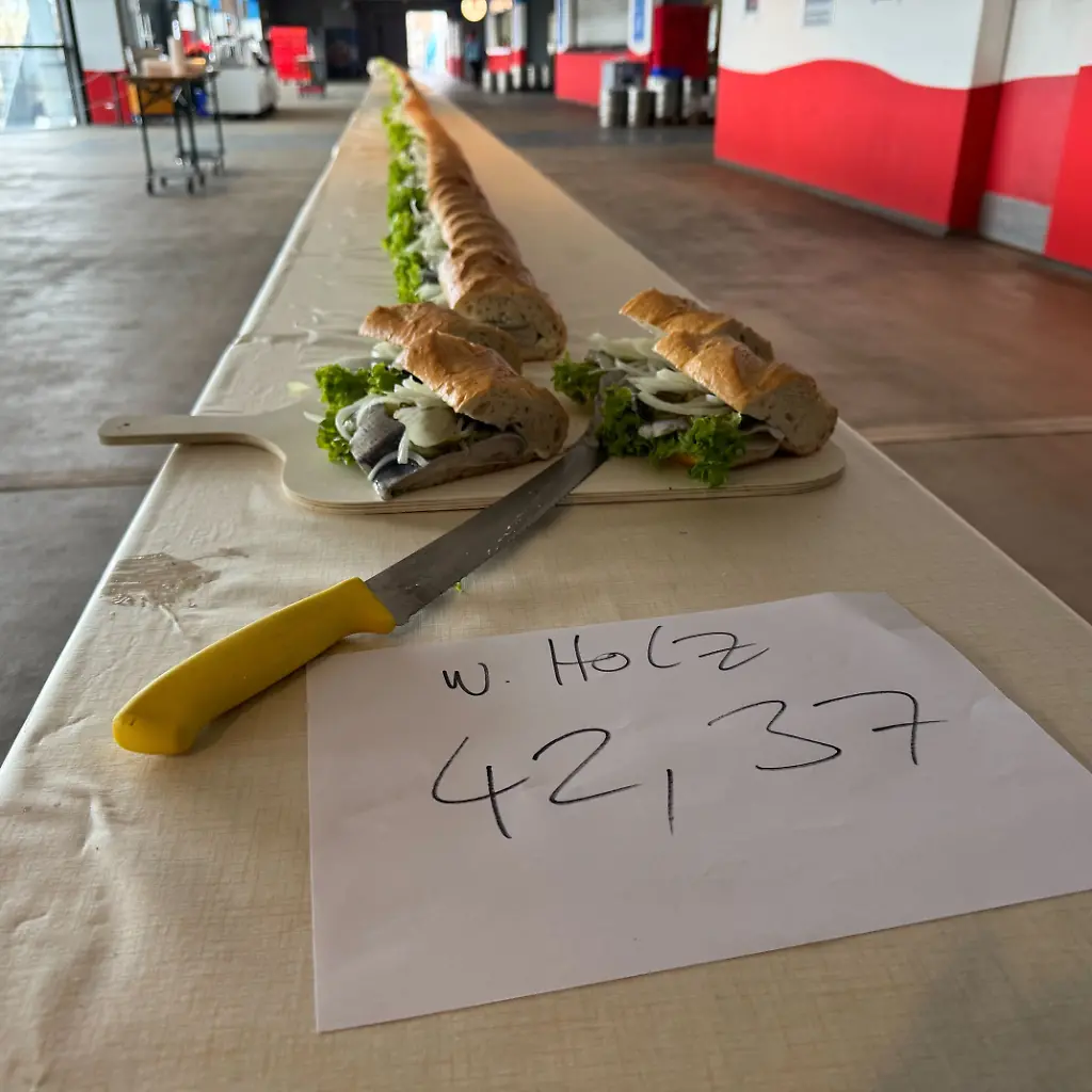 Das-Catering-Team-des-Ostseestadions-Rostock-hat-nach-Angaben-des-Rekord-Instituts-Deutschland-das-laengste-Fischbroetchen-der-Welt-produziert-Das-mit-Bismarckhering-Salatblaettern-Gewuerzgurken-und-Zwiebeln-belegte-Broetchen-ist-insgesamt-42-37-Meter-lang