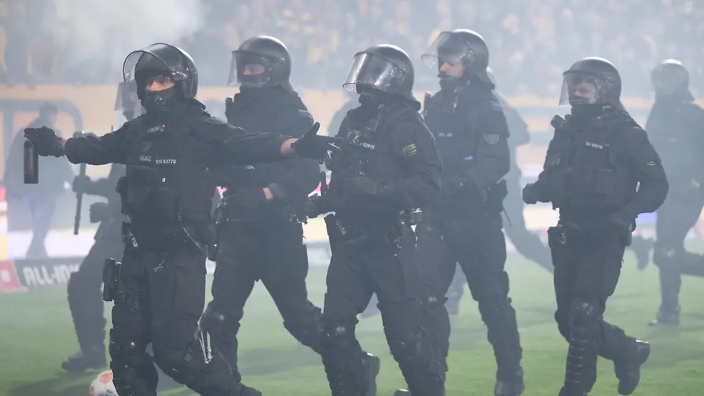 04-04-2026-Sachsen-Dresden-Fussball-Maenner-2-Bundesliga-Dynamo-Dresden-Hertha-BSC-28-Spieltag-im-Rudolf-Harbig-Stadion-Polizisten-stehen-waehrend-einer-Spielunterbrechung-im-Stadion-vor-dem-Gaesteblock-Foto-Sebastian-Kahnert-dpa-WICHTIGER-HINWEIS-Gemaess-den-Vorgaben-der-DFL-Deutsche-Fussball-Liga-bzw-des-DFB-Deutscher-Fussball-Bund-ist-es-untersagt-in-dem-Stadion-und-oder-vom-Spiel-angefertigte-Fotoaufnahmen-in-Form-von-Sequenzbildern-und-oder-videoaehnlichen-Fotostrecken-zu-verwerten-bzw-verwerten-zu-lassen