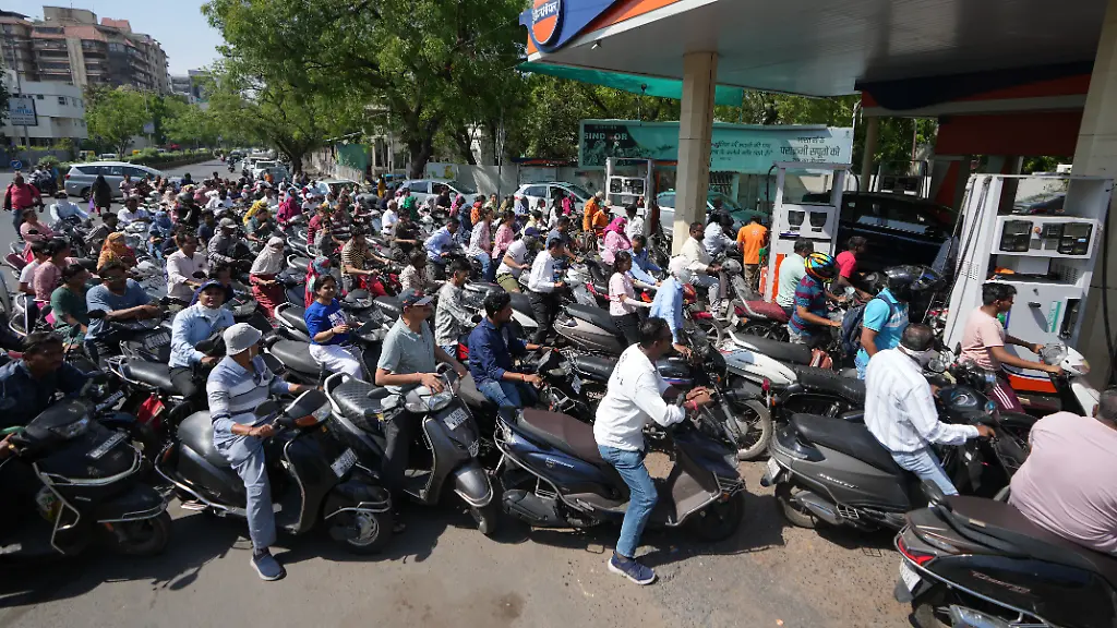 Motorrollerfahrer-stehen-an-einer-Tankstelle-vor-den-Zapfsaeulen-Schlange-weil-sie-einen-moeglichen-Treibstoffmangel-aufgrund-des-Iran-Kriegs-befuerchten
