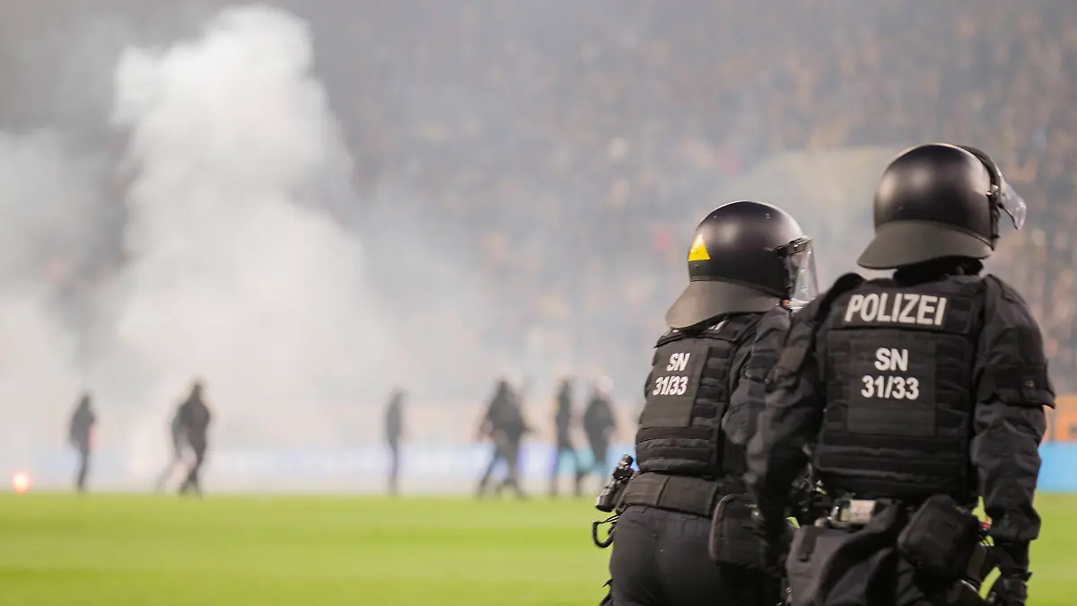 04-04-2026-xomx-Fussball-2-Bundesliga-Dynamo-Dresden-Hertha-BSC-Berlin-v-l-Platzsturm-Randale-Ausschreitungen-Pyros-Protechnik-Fackeln-Raketen-Beide-Fanlager-stuermen-das-Spielfeld-Jagdszenen-mit-der-Polizei-Einsatzkraefte-sichern-das-Spielfeld-und-draengen-Fans-zurueck-in-den-K-Block