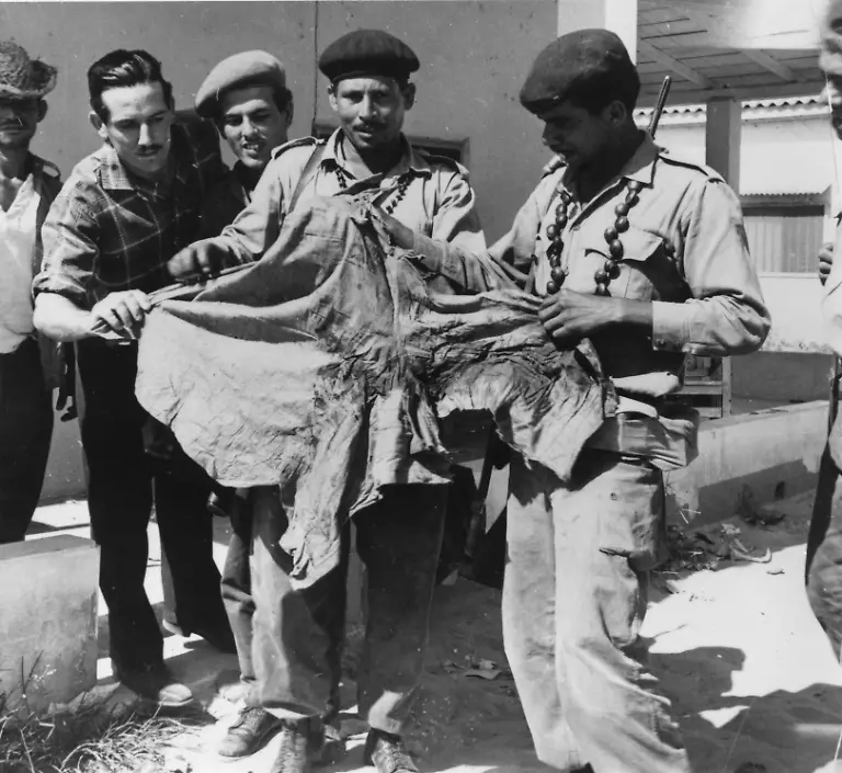 circa-1961-Castro-s-soldiers-looking-at-a-blood-stained-shirt-after-the-ill-fated-Bay-of-Pigs-invasion-at-Playa-de-Giron-Cuba