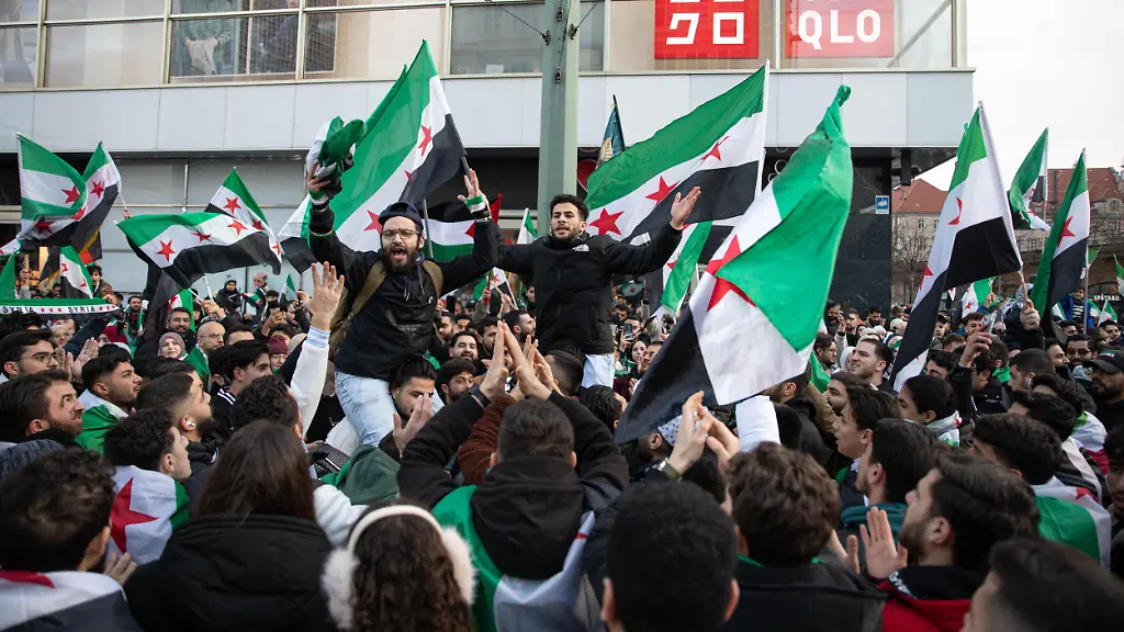On-Sunday-December-7-2025-large-crowds-of-Syrians-gather-at-Alexanderplatz-in-Berlin-Germany-waving-Syrian-and-German-flags-and-chanting-Freedom-for-Syria-ahead-of-Monday-s-anniversary-marking-the-fall-of-the-country-s-former-Assad-regime