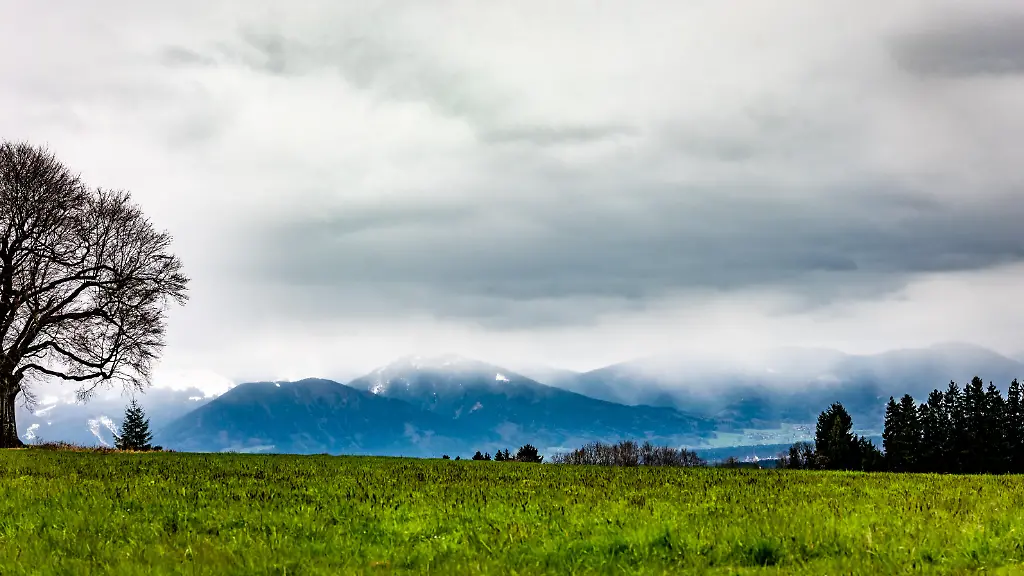 Blick-auf-die-wolkenverhangenen-Berge-in-der-Naehe-von-Riedering-in-Bayern