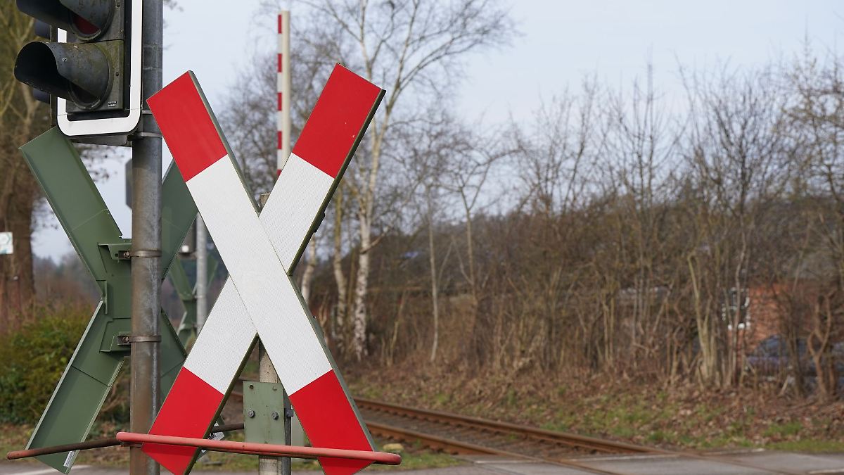 Sattelschlepper rangiert auf Bahnübergang - Schranken kaputt