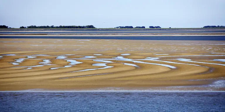 Nationalpark-Schleswig-Holsteinisches-Wattenmeer-bei-Niedrigwasser-mit-Sandbaenken-und-Festland-Nordfriesland-Deutschland-Europa