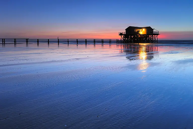Pfahlhaus-am-Strand-bei-Sonnenuntergang-ablaufendes-Wasser-bei-Ebbe-St