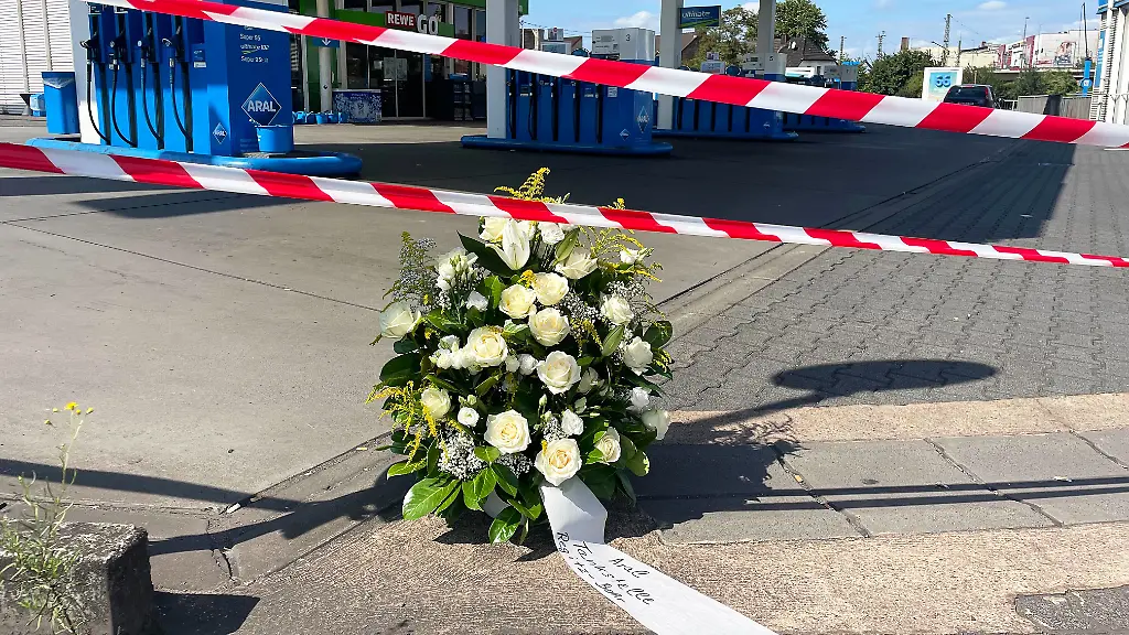 An-der-Tankstelle-an-der-nach-einem-Ueberfall-ein-Polizist-getoetet-wurde-haben-Mitarbeiter-einen-Kranz-niedergelegt-Nach-einem-Raubueberfall-auf-die-Tankstelle-ist-ein-Polizist-durch-Schuesse-getoetet-worden-Nach-Angaben-der-Polizei-hatte-der-mutmassliche-Taeter-dem-Beamten-bei-einem-Gerangel-die-Dienstwaffe-entrissen-und-geschossen