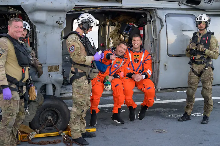 NASA-astronaut-Reid-Wiseman-Artemis-II-commander-and-CSA-Canadian-Space-Agency-astronaut-Jeremy-Hansen-Artemis-II-mission-specialist-react-while-sitting-on-a-Navy-MH-60-Seahawk-from-Helicopter-Sea-Combat-Squadron-HSC-23-on-the-flight-deck-of-USS-John-P-Murtha-after-they-and-fellow-crewmates-were-extracted-from-their-Orion-spacecraft-after-splashdown-in-the-Pacific-Ocean-off-the-coast-of-California-U-S-April-10-2026-NASA-Bill-Ingalls-Handout-via-REUTERS-THIS-IMAGE-HAS-BEEN-SUPPLIED-BY-A-THIRD-PARTY-MANDATORY-CREDIT