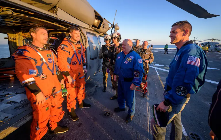 NASA-astronaut-Reid-Wiseman-Artemis-II-commander-and-CSA-Canadian-Space-Agency-astronaut-Jeremy-Hansen-Artemis-II-mission-specialist-talk-with-NASA-Administrator-Jared-Isaacman-on-the-flight-deck-of-USS-John-P-Murtha-after-they-and-fellow-crewmates-were-extracted-from-their-Orion-spacecraft-after-splashdown-in-the-Pacific-Ocean-off-the-coast-of-California-U-S-April-10-2026-NASA-Bill-Ingalls-Handout-via-REUTERS-THIS-IMAGE-HAS-BEEN-SUPPLIED-BY-A-THIRD-PARTY-MANDATORY-CREDIT-REFILE-CORRECTING-FROM-VICTOR-GLOVER-ARTEMIS-II-PILOT-TO-REID-WISEMAN-ARTEMIS-II-COMMANDER