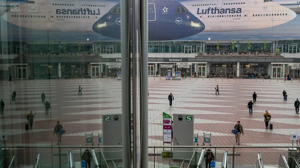 Passanten-gehen-am-Morgen-zum-Flughafen-Muenchen-Die-Pilotengewerkschaft-Vereinigung-Cockpit-hat-fuer-Montag-und-Dienstag-zu-Arbeitsniederlegungen-bei-der-Lufthansa-und-mehreren-Tochtergesellschaften-aufgerufen