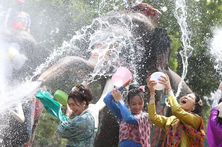 Menschen-und-Elefanten-spritzen-mit-Wasser-um-das-bevorstehende-Songkran-Fest-zu-feiern-Songkran-das-in-Thailand-normalerweise-vom-13-bis-15-April-gefeiert-wird-wird-auch-in-Laos-Kambodscha-und-Myanmar-begangen-Der-Feiertag-der-als-buddhistisches-Neujahrsfest-bekannt-ist-wurde-traditionell-mit-Besuchen-bei-Familienmitgliedern-und-dem-Uebergiessen-von-Buddha-Statuen-mit-duftendem-Wasser-begangen-Das-Werfen-von-Wasser-symbolisiert-das-Abwaschen-des-Ungluecks-des-vergangenen-Jahres
