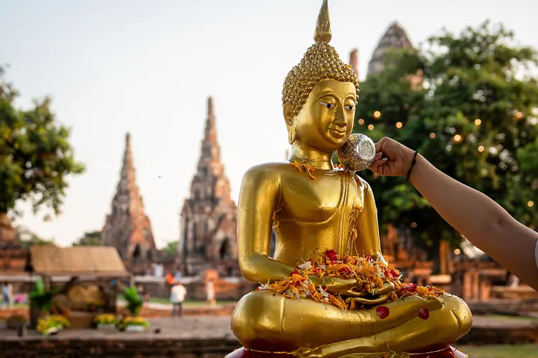 A-devotee-performs-Song-Nam-Phra-the-ritual-pouring-of-scented-water-over-Buddha-statue-ahead-of-Songkran-festivities-Preparation-at-Wat-Chaiwatthanaram-ahead-of-the-Songkran-kickoff-marking-Thai-New-Year-2026-with-vibrant-festivities-and-traditional-attire-set-against-one-of-the-most-majestic-temples-of-the-ancient-capital-of-Thailand-Ayutthaya