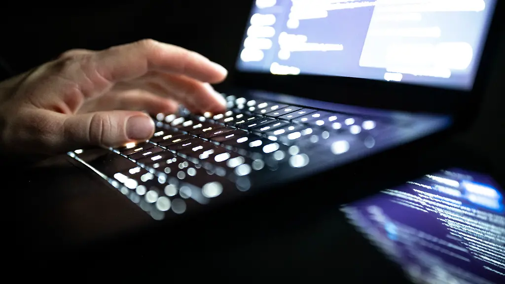 ILLUSTRATION-14-12-2025-NA-Berlin-Eine-Person-tippt-mit-den-Fingern-auf-einer-beleuchteten-Laptop-Tastatur
