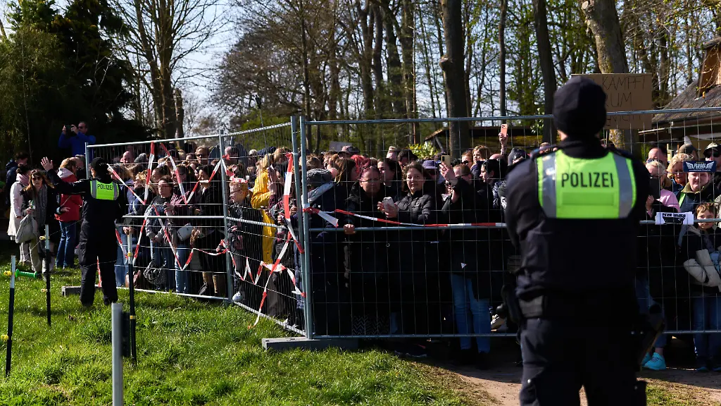 Teilnehmer-einer-Demonstration-fuer-die-Rettung-des-Buckelwals-stehen-hinter-einer-Polizeiabsperrung-Seit-zwoelf-Tagen-treibt-der-verletzte-Wal-in-der-Wismarbucht-vor-der-Insel-Poel-und-zeigt-weiterhin-Lebenszeichen
