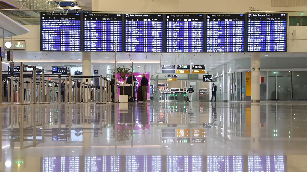 Eine-Anzeigetafel-spiegelt-sich-am-fruehen-Morgen-des-zweiten-Streiktages-der-Lufthansa-Piloten-auf-dem-Boden-der-Abflughalle-des-Terminals-2