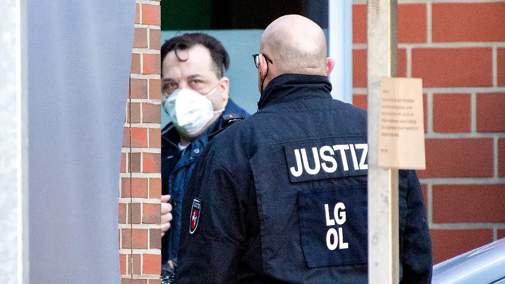08-03-2022-Niedersachsen-Oldenburg-Der-wegen-Mordes-verurteilte-Niels-Hoegel-wird-vor-Prozessbeginn-durch-einen-Nebeneingang-in-die-Weser-Ems-Hallen-gefuehrt-in-die-das-Landgericht-aus-Platzgruenden-den-Prozess-gegen-fruehere-Vorgesetzte-des-ehemaligen-Krankenpflegers-an-den-Kliniken-Oldenburg-und-Delmenhorst-verlegt-hat-Der-2019-wegen-85-Morden-verurteilte-Hoegel-soll-als-Zeuge-aussagen-Wegen-der-Mordserie-muessen-sich-Vorgesetzte-des-Ex-Krankenpflegers-der-Kliniken-Oldenburg-und-Delmenhorst-vor-Gericht-verantworten