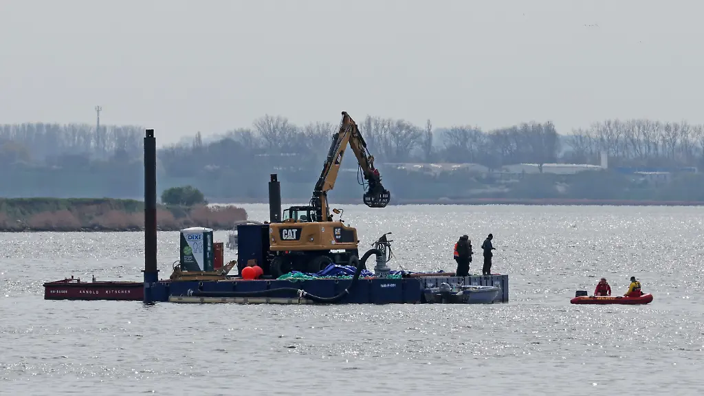 Ein-Arbeitsponton-mit-einem-speziellen-Bagger-und-kleinere-Begleitboote-sind-in-der-Naehe-des-gestrandeten-Buckelwals-vor-der-Insel-Poel-im-Einsatz-Fuer-den-bei-Wismar-gestrandeten-Buckelwal-soll-ein-neuer-Rettungsversuch-erfolgen-Umgesetzt-werden-soll-das-Konzept-von-einer-privaten-Initiative