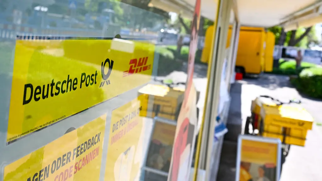 PRODUKTION-17-04-2026-Baden-Wuerttemberg-Stuttgart-Ein-Schild-mit-den-Logos-der-Post-und-DHL-haengt-vor-einer-Postfiliale-Das-flaechendeckende-Netz-an-Postfilialen-hat-Luecken