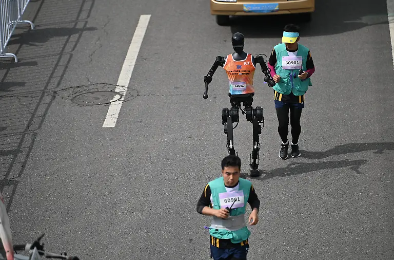 Der-humanoide-Roboter-Tian-Gong-laeuft-mit-einem-Mitarbeiter-einen-Halbmarathon-In-Peking-sind-humanoide-Roboter-bei-einem-Halbmarathon-gegen-Menschen-angetreten