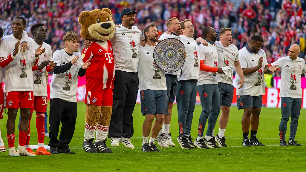 19-04-2026-Fussball-Bundesliga-2025-2026-30-Spieltag-FC-Bayern-Muenchen-VfB-Stuttgart-in-der-Allianz-Arena-Muenchen-der-FC-Bayern-feiert-nach-dem-heutigen-Sieg-seine-35-Deutsche-Meisterschaft-Die-Bayernspieler-feiern-mit-den-Fans-und-speziellen-Meistertrikots-mit-Aufdruck-des-kultigen-Porzellan-Kakadus-mit-Meisterschale-v-li-Tom-Bischof-Bayern-Muenchen-Luis-Diaz-FC-Bayern-Muenchen-Nicolas-Jackson-FC-Bayern-Muenchen-Bara-Sapoko-Ndiaye-Bayern-Muenchen-Lennart-Karl-FC-Bayern-Muenchen-Maskottchen-Berni-Trainer-Vincent-Kompany-FC-Bayern-Muenchen-danach-folgt-Staff-weiter-rechts-Co-Trainer-FLORIBERT-NGALULA-Rodyse-Munienge-Betreuer