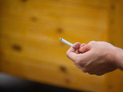 Ein Mann Haelt Eine Zigarette In Der Hand