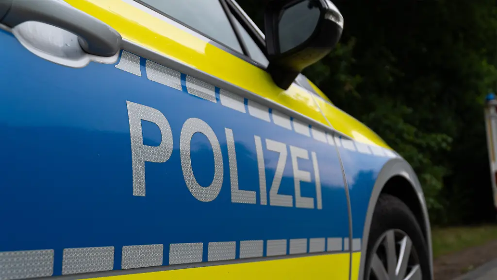 Landkreis-Osnabrueck-Deutschland-10-Juni-2025-Im-Bild-Caption-Nahaufnahme-des-Seitenbereichs-eines-deutschen-Polizeifahrzeugs-mit-dem-markanten-silberfarbenen-POLIZEI-Schriftzug-auf-blauem-Grund-Der-Schriftzug-ist-auf-einer-reflektierenden-Folie-angebracht-die-fuer-erhoehte-Sichtbarkeit-sorgt-Auffaellig-ist-die-leuchtend-gelbe-Kontrastfarbe-die-sich-von-der-Motorhaube-bis-zur-Tuer-zieht-und-von-einer-Reihe-reflektierender-Quadrate-begleitet-wird-Details-wie-der-Tuergriff-und-der-Aussenspiegel-sind-im-oberen-Bereich-des-Bildes-erkennbar-Das-Bild-repraesentiert-die-Praesenz-und-den-modernen-Auftritt-der-deutschen-Polizei