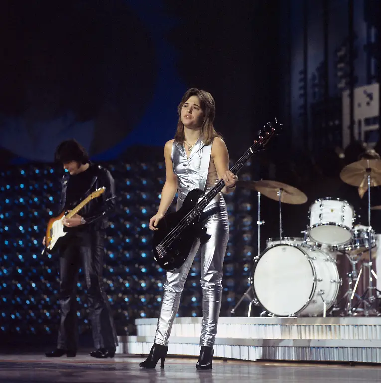 Die-US-amerikanische-Rocksaengerin-Suzi-Quatro-bei-ihrem-Auftritt-im-Palast-der-Republik-aufgenommen-1978-in-Ost-Berlin-Im-Hintergrund-ist-der-Gitarrist-Len-Tuckey-zu-sehen-mit-dem-Suzi-Quatro-lange-Jahre-verheiratet-war