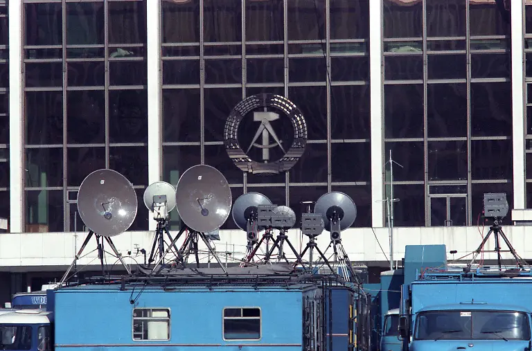 Zur-ersten-freien-Wahl-der-Volkskammer-in-der-DDR-steht-die-Uebertragungstechnik-von-Fernsehstationen-aus-aller-Welt-auf-dem-Marx-Engels-Platz-Schlossplatz-in-Berlin-Ost-vor-dem-Palast-der-Republik-Rund-vier-Monate-nach-dem-Mauerfall-wird-am-18-Maerz-1990-die-Volkskammer-erstmals-frei-gewaehlt