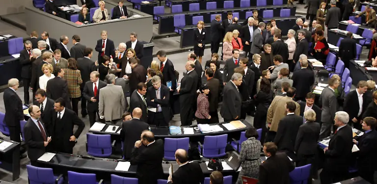 Die-Abgeordneten-des-Deutschen-Bundestages-stehen-am-Donnerstag-19-01-2006-im-Reichstag-in-Berlin-waehrend-der-Abstimmung-ueber-den-Abriss-des-Palastes-der-Republik-neben-den-Urnen-Das-Aus-fuer-den-Palast-am-Berliner-Schlossplatz-war-spaeter-endgueltig-Der-Bundestag-lehnte-mit-grosser-Mehrheit-einen-Aufschub-fuer-den-Abriss-des-realsozialistischen-Bauwerks-in-der-historischen-Mitte-der-Hauptstadt-ab-In-namentlicher-Abstimmung-fielen-entsprechende-Antraege-von-Gruenen-und-Linkspartei-durch-Die-Vorbereitungen-fuer-die-Demontage-der-asbestsanierten-Ruine-in-der-frueher-auch-die-DDR-Volkskammer-residierte-laufen-bereits