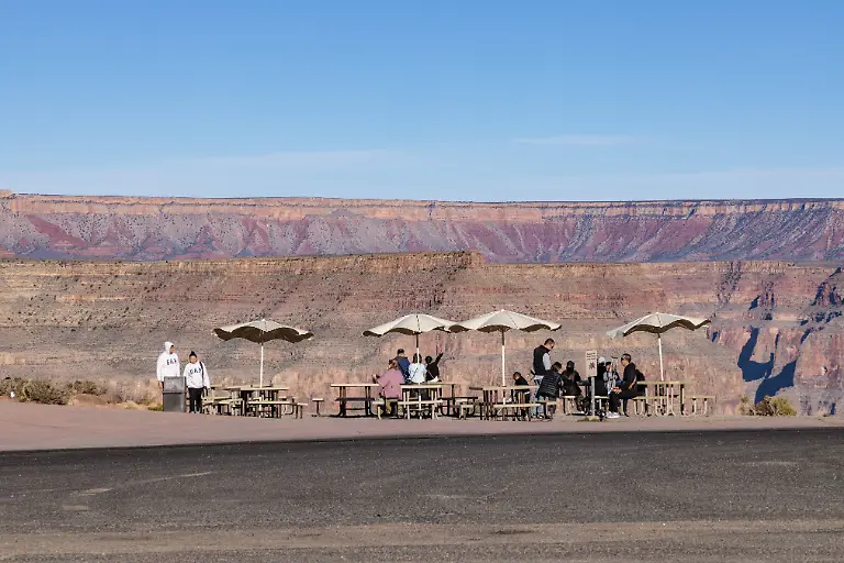 Touristen-die-an-ueberdachten-Picknicktischen-am-Guano-Point-im-Grand-Canyon-West-in-der-Naehe-von-Peach-Springs-Arizona-auf-den-Bustransport-warten-Tourists-waiting-for-bus-transportation-at-covered-picnic-tables-at-Guano-Point-in-Grand-Canyon-West-near-Peach-Springs-Arizona-Copyright-imageBROKER-RonxBuskirk-iblbus13962417