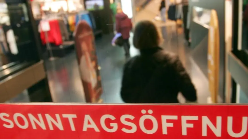 Ein-Schild-weist-an-einem-Kaufhaus-auf-die-Oeffnung-am-Sonntag-hin