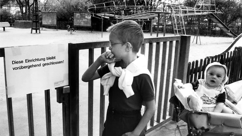 A-boy-looks-at-a-notice-fixed-to-the-locked-gate-of-a-playground-in-Wiesbaden-May-5-1986-that-reads-This-ground-is-perliminarily-closed-A-week-after-the-atomic-reactor-explosion-in-Chernobyl-on-April-26-1986-the-city-council-closed-all-playgrounds-after-detecting-nuclear-radiation-levels-of-124-to-280-Becquerel-AP-Photo-Frank-Rumpenhorst-SPIELPLAETZE-GESCHLOSSEN-Vor-verschlossenen-Tueren-stehen-hier-der-achtjaehrige-Benjamin-Winkelmann-und-sein-sechs-Monate-alter-Cousin-Johannes-nachdem-die-Stadt-Wiesbaden-am-Montag-saemtliche-Kinderspielplaetze-bis-auf-weiteres-geschlossen-hat-Die-Massnahme-wurde-getroffen-nachdem-am-Wochenende-erhoehte-Radioaktivitaetswerte-zwischen-124-und-280-Becquerel-festgestellt-wurden