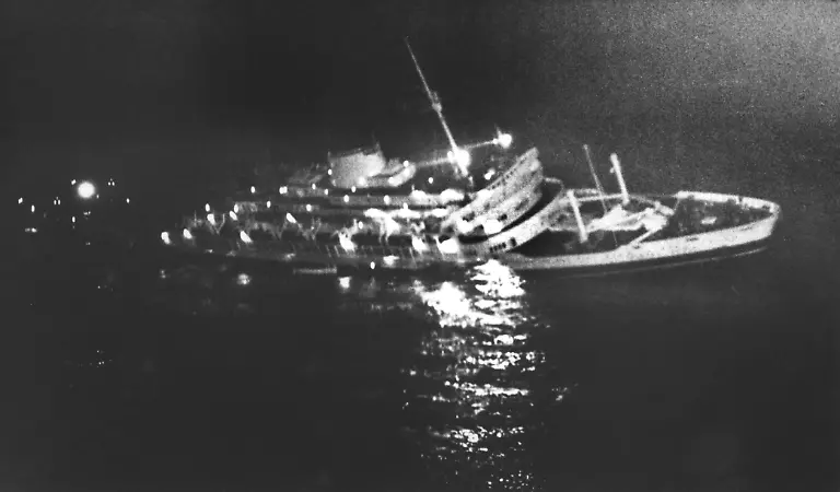 Die-Lichter-der-untergehenden-Andrea-Doria-spiegeln-sich-im-Meer-Das-italienische-Luxusschiff-sinkt-am-26-07-1956-nach-einem-Zusammenstoss-mit-dem-schwedischen-Dampfer-Stockholm-vor-der-amerikanischen-Ostkueste-Ueber-1650-Passagiere-konnten-gerettet-werden-51-Menschen-kamen-ums-Leben-Aufnahme-vom-26-07-1956-Achtung-Die-Angaben-zur-Zahl-der-Toten-bei-dem-Zusammenstoss-der-Andrea-Doria-und-der-Stockholm-schwanken-In-einigen-Quellen-wird-von-insgesamt-46-Toten-berichtet-andere-sprechen-von-46-Toten-auf-der-Andrea-Doria-und-fuenf-auf-der-Stockholm