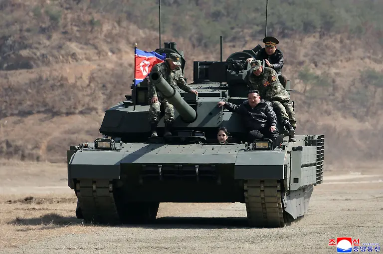 Die-von-der-staatlichen-nordkoreanischen-Nachrichtenagentur-KCNA-am-19-03-2026-zur-Verfuegung-gestellte-Aufnahme-zeigt-nach-Angaben-von-KCNA-den-Machthaber-von-Nordkorea-Kim-Jong-Un-vorne-r-der-zusammen-mit-seiner-Tochter-Kim-Ju-ae-vorne-mit-einem-Panzer-auf-einem-militaerischen-Ausbildungsstuetzpunkt-faehrt-Unabhaengige-Journalisten-hatten-keinen-Zugang-zu-dem-Ereignis-das-auf-diesem-von-der-nordkoreanischen-Regierung-verbreiteten-Bild-zu-sehen-ist-Der-Inhalt-dieses-Bildes-ist-so-wie-er-zur-Verfuegung-gestellt-wurde-und-kann-nicht-unabhaengig-ueberprueft-werden-Das-Wasserzeichen-in-koreanischer-Sprache-auf-dem-Bild-lautet-wie-von-der-Quelle-angegeben-KCNA-ist-die-Abkuerzung-fuer-Korean-Central-News-Agency