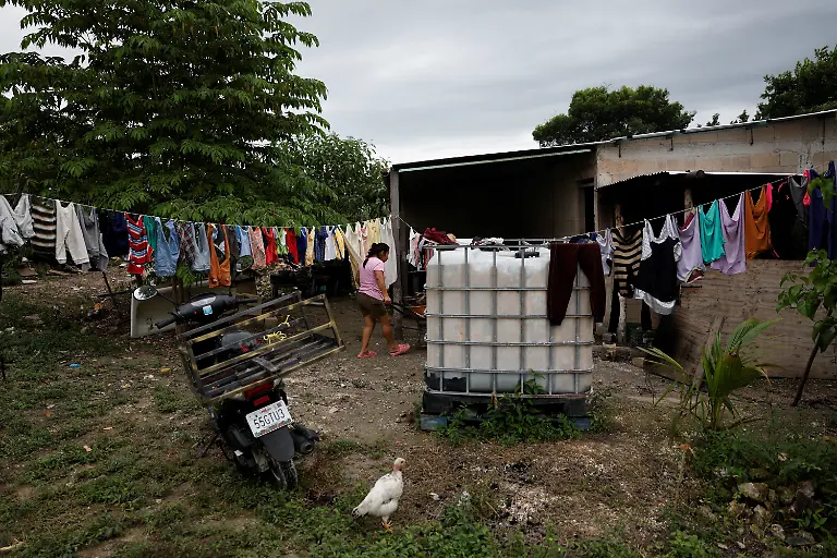 A-woman-hangs-clothes-at-her-home-in-a-village-where-residents-collect-rainwater-for-daily-use-because-of-a-lack-of-drinking-water-in-Xpujil-Campeche-state-Mexico-November-14-2025-Mexico-s-1-500-km-Mayan-Train-was-launched-to-drive-development-in-the-country-s-impoverished-south-through-infrastructure-and-tourism-but-two-years-after-its-inauguration-it-is-struggling-financially-ticket-sales-cover-only-a-fraction-of-costs-hotels-remain-largely-empty-and-communities-along-the-route-say-poverty-persists-and-promised-benefits-have-yet-to-materialize-A-Reuters-review-of-census-data-and-interviews-with-residents-along-the-line-found-that-poverty-remains-widespread-and-well-paid-jobs-scarce-despite-the-project-REUTERS-Daniel-Becerril-SEARCH-BECERRIL-MAYA-TRAIN-FOR-THIS-STORY-SEARCH-WIDER-IMAGE-FOR-ALL-STORIES