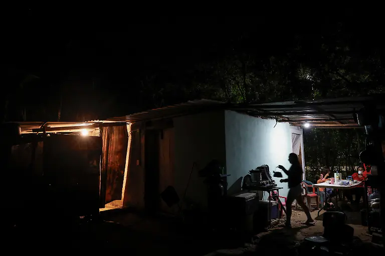 Mary-Sandra-Peraza-30-cooks-dinner-for-her-family-at-their-home-where-they-have-no-electricity-and-rely-on-solar-panels-and-a-generator-for-daily-tasks-near-a-Maya-Train-station-with-full-electrical-service-in-Vida-y-Esperanza-Quintana-Roo-state-Mexico-November-10-2025-Mexico-s-1-500-km-Mayan-Train-was-launched-to-drive-development-in-the-country-s-impoverished-south-through-infrastructure-and-tourism-but-two-years-after-its-inauguration-the-local-communities-near-the-line-say-they-have-seen-little-benefit-A-Reuters-review-of-census-data-and-interviews-with-dozens-of-residents-in-towns-along-the-track-found-that-poverty-remains-entrenched-and-well-paying-jobs-hard-to-find-It-s-not-like-we-re-asking-for-much-said-Peraza-There-s-no-real-benefit-for-us-REUTERS-Daniel-Becerril-SEARCH-BECERRIL-MAYA-TRAIN-FOR-THIS-STORY-SEARCH-WIDER-IMAGE-FOR-ALL-STORIES