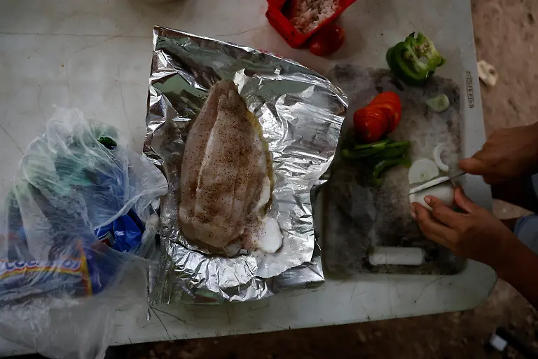 Mary-Sandra-Peraza-30-cooks-breakfast-for-her-family-at-their-home-where-they-lack-electricity-and-rely-on-solar-panels-and-a-generator-for-daily-tasks-near-a-Maya-Train-station-with-full-electrical-service-in-Vida-y-Esperanza-Quintana-Roo-state-Mexico-November-11-2025-Mexico-s-1-500-km-Mayan-Train-was-launched-to-drive-development-in-the-country-s-impoverished-south-through-infrastructure-and-tourism-but-two-years-after-its-inauguration-the-local-communities-near-the-line-say-they-have-seen-little-benefit-A-Reuters-review-of-census-data-and-interviews-with-dozens-of-residents-in-towns-along-the-track-found-that-poverty-remains-entrenched-and-well-paying-jobs-hard-to-find-It-s-not-like-we-re-asking-for-much-said-Peraza-There-s-no-real-benefit-for-us-REUTERS-Daniel-Becerril-SEARCH-BECERRIL-MAYA-TRAIN-FOR-THIS-STORY-SEARCH-WIDER-IMAGE-FOR-ALL-STORIES