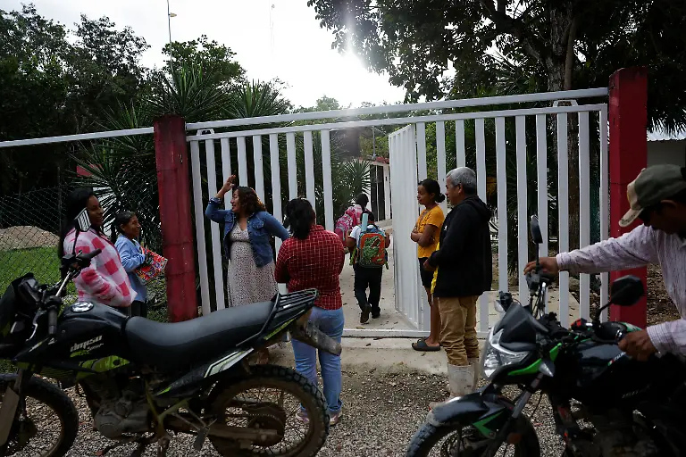 Teacher-Lidia-Patricia-Chan-Us-welcomes-her-students-to-a-school-without-electricity-near-a-fully-powered-Maya-Train-station-in-Vida-y-Esperanza-Quintana-Roo-state-Mexico-November-11-2025-Chan-Us-has-spent-years-trying-to-get-power-connected-but-the-authorities-have-told-her-electricity-cannot-be-installed-until-the-land-beneath-the-school-has-formal-titles-a-red-tape-issue-common-for-rural-communal-plots-like-this-which-she-had-hoped-might-change-with-the-arrival-of-a-mega-project-that-the-government-had-vowed-would-spur-development-and-progress-At-the-beginning-when-the-project-came-along-we-were-happy-about-it-Chan-Us-said-Some-residents-sold-food-to-construction-workers-which-she-said-was-a-benefit-to-the-community-But-when-the-construction-ended-just-as-quickly-as-it-arrived-it-was-gone-REUTERS-Daniel-Becerril-SEARCH-BECERRIL-MAYA-TRAIN-FOR-THIS-STORY-SEARCH-WIDER-IMAGE-FOR-ALL-STORIES