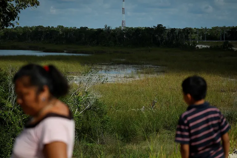 Matilde-Kinil-Pool-53-walks-with-her-grandson-Leyner-Jesus-Chan-Kumul-near-a-pond-where-they-once-fished-in-Uh-May-Quintana-Roo-state-Mexico-November-16-2025-Historically-marginalized-Maya-populations-in-Mexico-s-southeast-have-long-faced-high-poverty-rates-and-limited-access-to-services-and-while-the-Mayan-Train-was-promoted-as-a-way-to-bring-development-to-Indigenous-Maya-communities-many-community-activists-say-instead-that-their-forests-have-been-fragmented-communal-lands-eroded-and-traditions-strained-For-many-Maya-the-land-over-which-it-runs-is-their-sacred-inheritance-central-to-their-identity-and-linking-them-to-their-ancestors-REUTERS-Daniel-Becerril-SEARCH-BECERRIL-MAYA-TRAIN-FOR-THIS-STORY-SEARCH-WIDER-IMAGE-FOR-ALL-STORIES